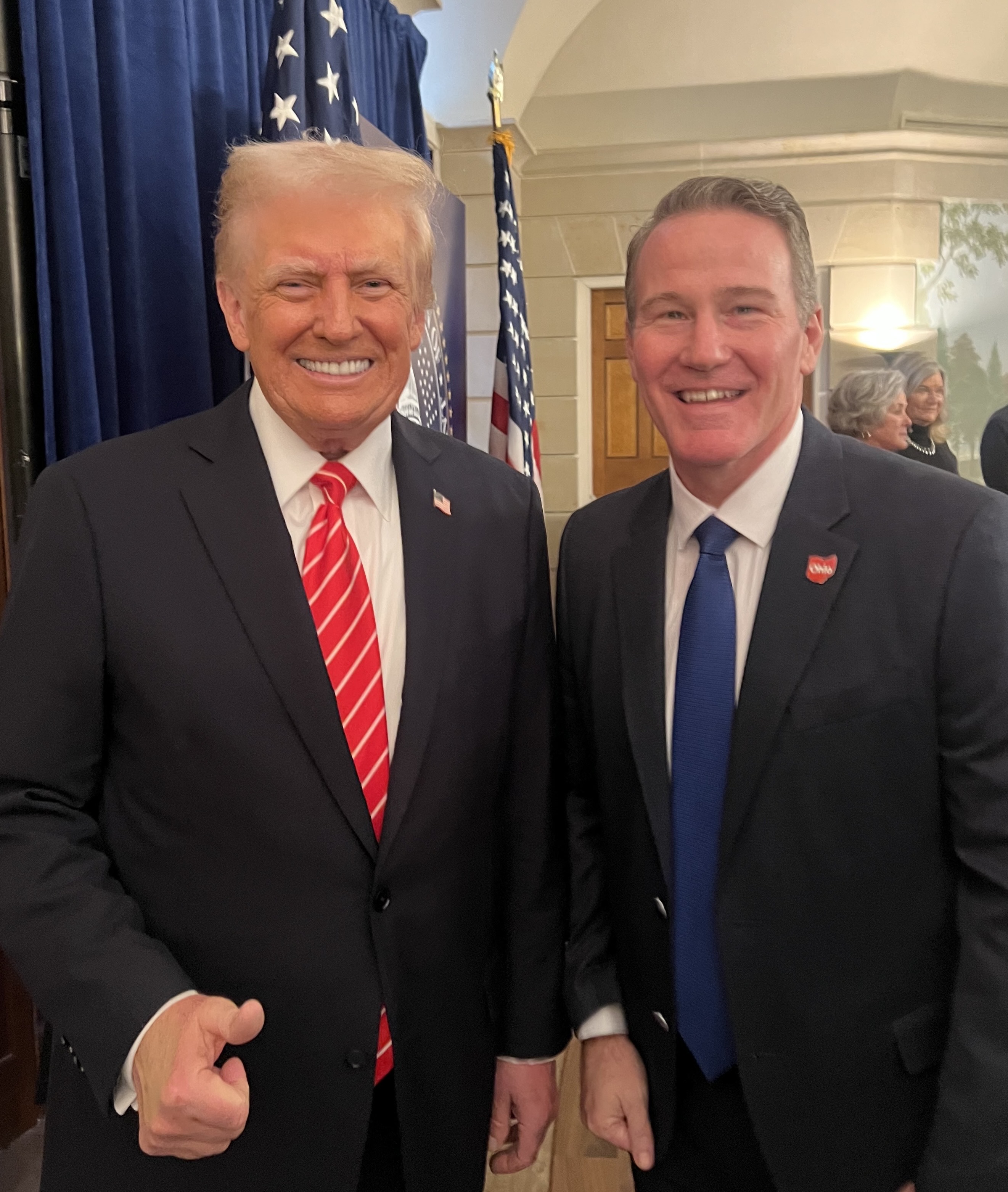 Senator Jon Husted speaking at a podium in Columbus, Ohio
