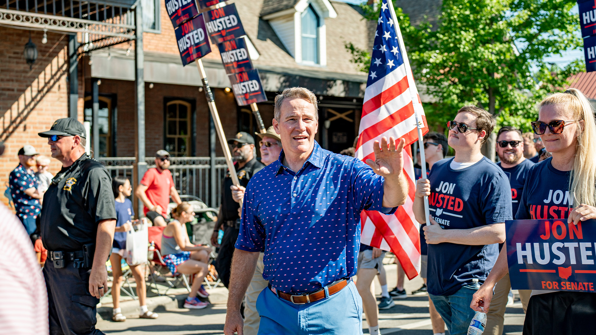 Senator Jon Husted waving as he walks in a parade